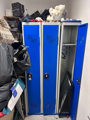 a blue locker in a room with a lot of trash