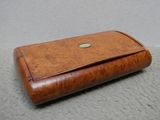 une petite boîte en bois sur laquelle se trouve un bouton