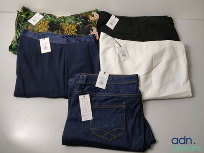 trois paires de jeans, encore étiquetées, posées sur une table