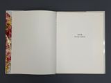 an open book with a picture of flowers on it