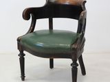 a chair with a green leather seat in a white room