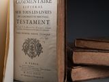 an open book sitting on top of a table next to a stack of books