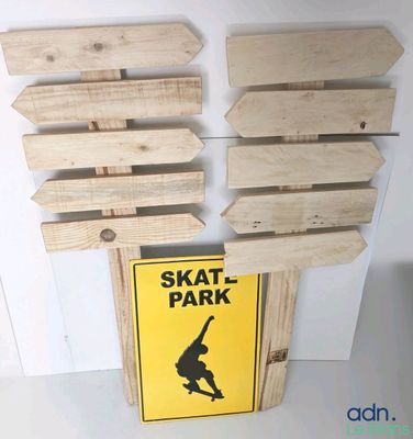 a skate park sign on the wall next to a skateboard sign