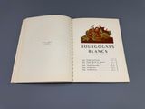 un livre ouvert sur lequel figure l'image d'une grappe de raisin