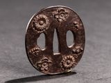 a small metal object with a flower design on it