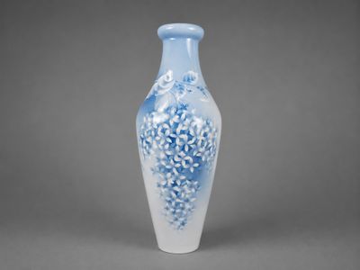 un vase bleu et blanc posé sur une surface grise