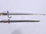 a pair of old swords on a white surface