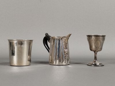 trois tasses en argent posées l'une à côté de l'autre sur une table