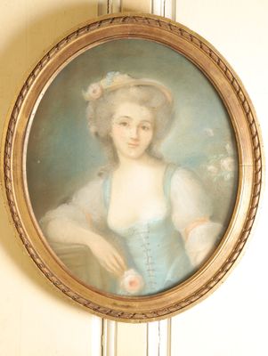 un tableau représentant une femme en robe bleue accroché au mur