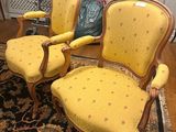 three yellow chairs sitting on a rug in a living room