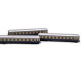 three toy trains sitting next to each other on a white surface