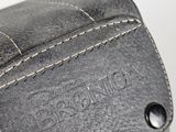 the back of a black leather bag with a zipper on it