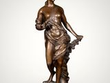 a bronze statue of a woman holding a basket of flowers