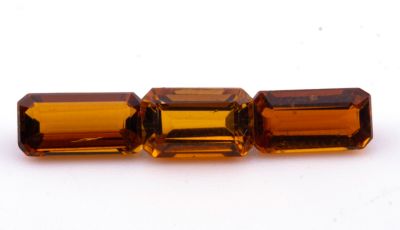 un gros plan sur trois perles rectangulaires en citrine posées sur une surface blanche