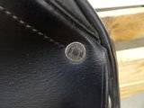 a close up of a black purse with a button on it