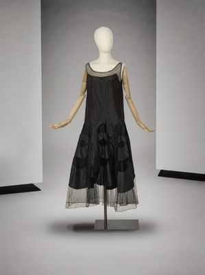 une photo d'un mannequin vêtu d'une robe noire, posé sur un pied