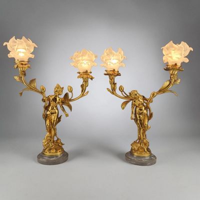 a pair of antique brass candlesticks with flowers and angels