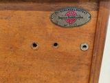 a small wooden box with a metal label on it