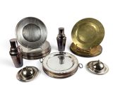de nombreux objets en argent et en laiton posés sur un fond blanc