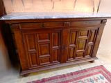 a wooden cabinet with a marble top in a room