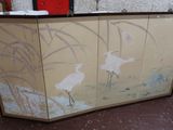 two birds painted on a screen in a room