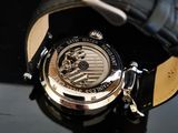 a close up of a watch on a black surface