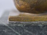 a close up picture of a bronze bowl on a marble base