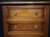 a wooden chest of drawers with brass knobs on it