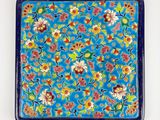un gros plan d'une assiette bleue décorée de fleurs et de feuilles
