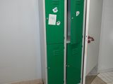 un casier vert dans une salle de bains avec des toilettes dans un coin
