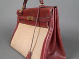 an image of a red and beige handbag on a gray surface