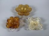 three pieces of glass sitting next to each other on a white surface