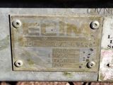 a close up of a metal sign on a bench