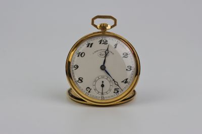 une montre de poche en or avec un cadran blanc sur une surface blanche