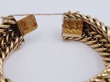 an image of a close up of a gold bracelet on a white surface