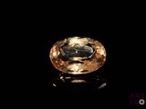 a close up of a yellow diamond on a black surface