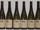 six bottles of wine are lined up on a table
