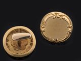 two pieces of gold and silver jewelry on a black surface