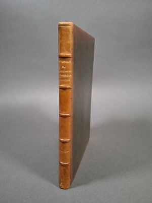 un vieux livre posé sur une table à côté d'un fond gris