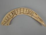 carved horn with musical notes on it on a gray surface