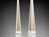 pair of white pedestals with a bird on top of them