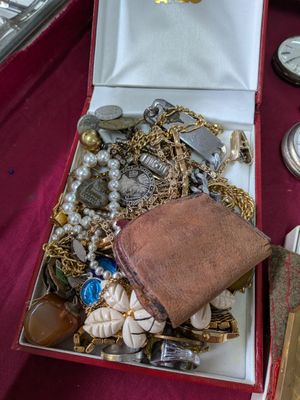 une boîte remplie de bijoux variés posée sur une table rouge