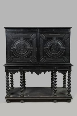 une armoire en bois noir à deux portes, surmontée d'une étagère