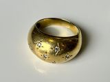 une bague en or sertie de diamants, posée sur un fond blanc