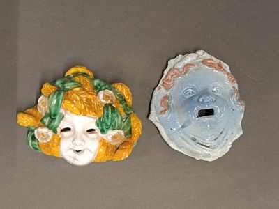 Ensemble de deux masques de putti en céramique.