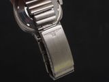 a person holding a watch in their hand on a black background