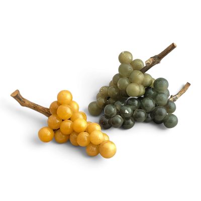 deux grappes de raisin posées sur une surface blanche