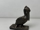 statue en bronze représentant un pélican, posée sur un socle en marbre