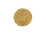 a close up of a gold coin on a white surface