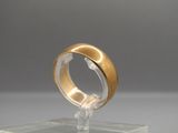 an image of a gold ring on a clear stand